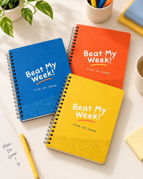 Blue, Orange and Yellow Beat My Week student planners arranged on a study workspace