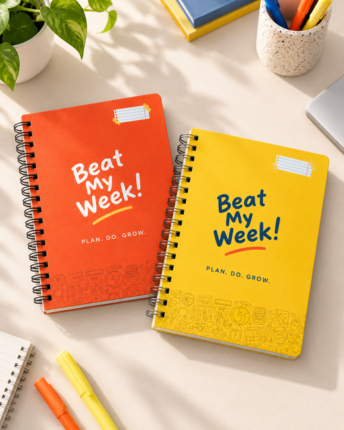 Orange and Yellow Beat My Week 12-week student planners on a bright study desk